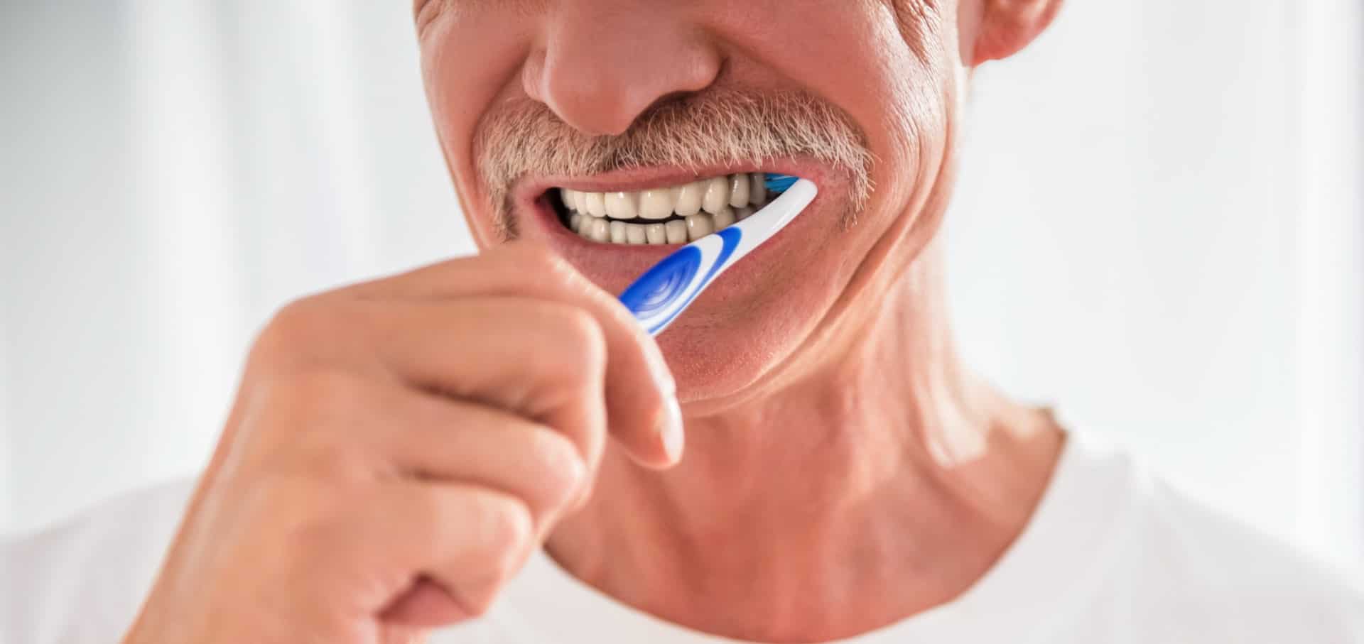 Senior realizando su limpieza de implantes dentales